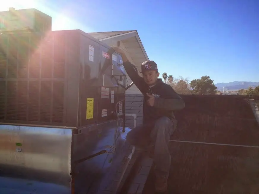 HVAC technician performing Heat Pump Repair on a rooftop unit in Jarrell